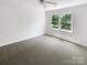 Large bedroom featuring carpeted flooring, ceiling fan, and natural light from a window at 1507 Chadmore Nw Ln, Concord, NC 28027