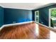 Bedroom featuring a bold blue wall, hardwood flooring, and ample natural light at 1507 Chadmore Nw Ln, Concord, NC 28027