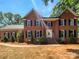 Charming two-story brick home with manicured landscaping and classic blue shutters on a sunny day at 1507 Chadmore Nw Ln, Concord, NC 28027