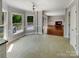 Bright living area featuring large windows, tile flooring, and access to an outdoor deck overlooking backyard at 1507 Chadmore Nw Ln, Concord, NC 28027