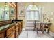 Bathroom featuring tub under arched window, custom vanity, and bright natural lighting at 1720 Mills Harris Rd, Wingate, NC 28174