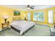 Bright bedroom with yellow walls, features a neutral bed, complemented by two side tables with lamps, offering a cozy retreat at 1720 Mills Harris Rd, Wingate, NC 28174