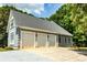 Three-car garage with white doors, situated on a wide concrete driveway, providing ample parking and storage space at 1720 Mills Harris Rd, Wingate, NC 28174