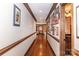 Long hallway with hardwood floors, showcasing framed photos and decorative trim, leading to various rooms in the home at 1720 Mills Harris Rd, Wingate, NC 28174