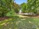 The large backyard featuring mature trees and a spacious deck for relaxing and enjoying nature at 17501 Youngblood Rd, Charlotte, NC 28278