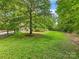 Expansive backyard, perfect for outdoor activities with mature trees providing ample shade and privacy at 17501 Youngblood Rd, Charlotte, NC 28278