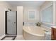 Bright bathroom with bathtub, walk-in shower, and natural light at 17501 Youngblood Rd, Charlotte, NC 28278