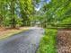 Home featuring a long driveway and wooden fence, creating a picturesque and private entrance at 17501 Youngblood Rd, Charlotte, NC 28278