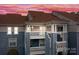 A beautiful exterior showcasing a multi-story condo building with charming balconies under a pink and purple sky at 18669 Vineyard Point Ln, Cornelius, NC 28031