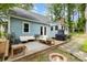 Backyard patio with cozy seating, grill, brick fire pit and mature landscaping at 200 Cleveland Ave, Shelby, NC 28150