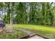 Home's backyard featuring a brick fire pit, a shed, and mature landscaping at 200 Cleveland Ave, Shelby, NC 28150