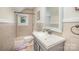 Bathroom with tiled shower, toilet, and vanity with framed mirror and updated fixtures at 200 Cleveland Ave, Shelby, NC 28150