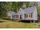 Charming light-blue home featuring a covered porch, manicured lawn, and mature trees providing a serene backdrop at 200 Cleveland Ave, Shelby, NC 28150