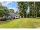 Home's exterior showing a patio, fire pit, mature trees, and a shed on a large lot at 200 Cleveland Ave, Shelby, NC 28150