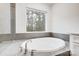 Bright bathroom showcasing a modern soaking tub beneath a large window with views of the outside at 2011 Cedar Falls Dr # 71, Waxhaw, NC 28173