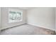A well-lit bedroom featuring plush carpet flooring and a window with exterior views at 2011 Cedar Falls Dr # 71, Waxhaw, NC 28173