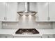 Close-up of the kitchen range with stainless steel hood and white subway tile backsplash at 2011 Cedar Falls Dr # 71, Waxhaw, NC 28173