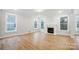 Bright living room featuring a cozy fireplace, large windows, and beautiful hardwood flooring at 2011 Cedar Falls Dr # 71, Waxhaw, NC 28173