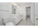 Bathroom with double sinks, a toilet, and a large mirror with lighting at 2021 Boynton St, Charlotte, NC 28269