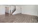 Bright, open living room with wood-look flooring and staircase at 2021 Boynton St, Charlotte, NC 28269