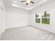 Bright bedroom featuring tray ceiling, ceiling fan, and large window providing natural light at 220 S Columbia St, Gastonia, NC 28054