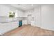 Well-lit kitchen showcases white cabinetry, granite countertops, a blue dishwasher, stainless steel sink, and light wood-look flooring at 220 S Columbia St, Gastonia, NC 28054