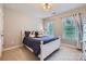 Bedroom featuring a white bed frame, plush bedding, and dual windows providing natural light at 2215 Maycroft Dr, Charlotte, NC 28262
