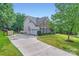 Side exterior view with a basketball hoop and a spacious driveway at 2215 Maycroft Dr, Charlotte, NC 28262