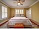 Bright bedroom featuring a large bed, plantation shutters, and hardwood floors at 226 Union S St, Concord, NC 28025
