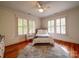 Cozy bedroom featuring hardwood floors, shuttered windows, a ceiling fan, and neutral decor at 226 Union S St, Concord, NC 28025