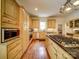 This kitchen is equipped with wooden cabinetry, granite countertops, stainless steel appliances, and a center island cooktop at 226 Union S St, Concord, NC 28025
