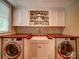 This cozy laundry room includes a utility sink, wooden countertop, white cabinets, and modern washer and dryer at 226 Union S St, Concord, NC 28025