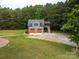 Garage with apartment, surrounded by mature trees, lush lawn and long driveway at 2609 Cove Creek Dr, Gastonia, NC 28056