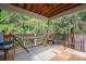 Relaxing covered deck featuring a hammock and bench overlooking a lush green forest at 2609 Cove Creek Dr, Gastonia, NC 28056