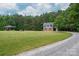 Gravel driveway leads to house with lawn, side staircase, and detached garage at 2609 Cove Creek Dr, Gastonia, NC 28056