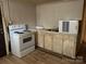 Kitchen with dated appliances, including an electric range, and worn cabinetry at 2703 E Greenbriar Rd, Statesville, NC 28625