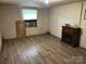 Living room featuring laminate wood flooring, a faux fireplace, and a window air conditioner at 2703 E Greenbriar Rd, Statesville, NC 28625