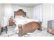 Bedroom with an ornate wooden bed frame, matching nightstand, neutral linens, and light gray wood-look flooring at 303 Island Ford Rd, Maiden, NC 28650