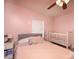 Cozy pink bedroom with a crib, a queen bed, a ceiling fan, and light-colored vinyl flooring at 303 Island Ford Rd, Maiden, NC 28650