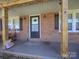 Charming front porch with brick accents, rocking chairs, and a covered entryway at 303 Island Ford Rd, Maiden, NC 28650