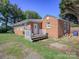 Charming, single-story brick home features a quaint front porch and well-maintained lawn on a sunny day at 303 Island Ford Rd, Maiden, NC 28650