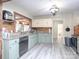 Well lit kitchen with green cabinets, wooden backsplash, stainless steel appliances, and grey wood-look flooring at 303 Island Ford Rd, Maiden, NC 28650