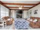 Cozy living room features exposed wood beams, a brick fireplace, and comfortable seating for relaxing at 303 Island Ford Rd, Maiden, NC 28650