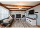 Charming living room features a brick fireplace, wood beams, ample windows and hardwood floors at 303 Island Ford Rd, Maiden, NC 28650