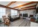 Cozy living room featuring a brick fireplace, wood beams, ample windows, and hardwood floors at 303 Island Ford Rd, Maiden, NC 28650