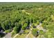 An aerial shot reveals a serene neighborhood bordering expansive woodlands and a verdant, open meadow at 319 Beacon Hills Dr, Gastonia, NC 28056