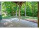 Covered patio with a concrete floor, lush landscaping, and wooded views at 319 Beacon Hills Dr, Gastonia, NC 28056
