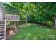 Large, grassy backyard with a wooden deck and a backdrop of mature trees at 319 Beacon Hills Dr, Gastonia, NC 28056