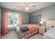 Cozy bedroom with neutral walls, ceiling fan, and natural light from the large window at 319 Beacon Hills Dr, Gastonia, NC 28056