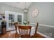 Cozy dining area with wooden table, chairs, white tablecloth, and French doors leading to the outside at 319 Beacon Hills Dr, Gastonia, NC 28056